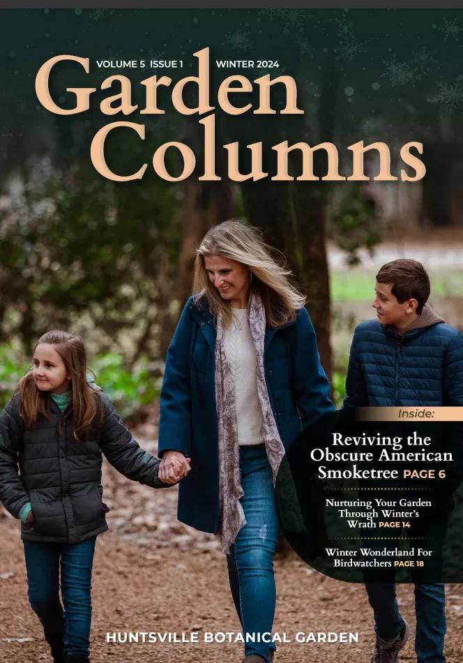 A woman and two children walk through the Garden on the cover of the Garden Columns Magazine